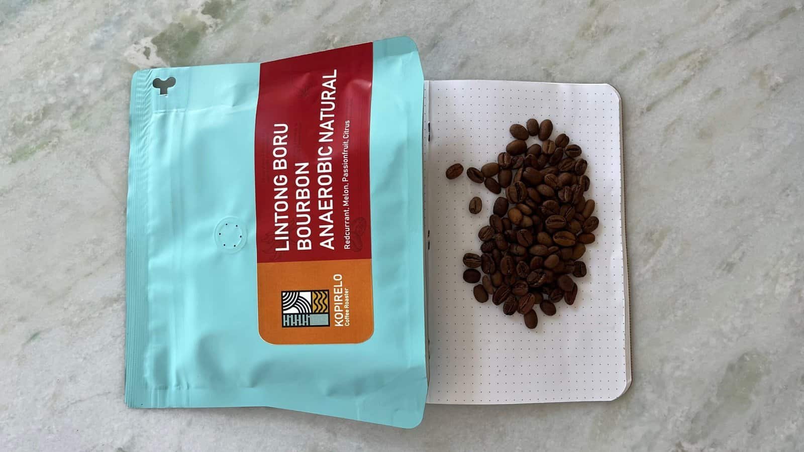 Rich, dark roasted coffee beans spilled from a resealable bag onto a white dotted surface, showcasing high-quality speciality coffee for coffee enthusiasts and connoisseurs, perfect for artisanal brewing.