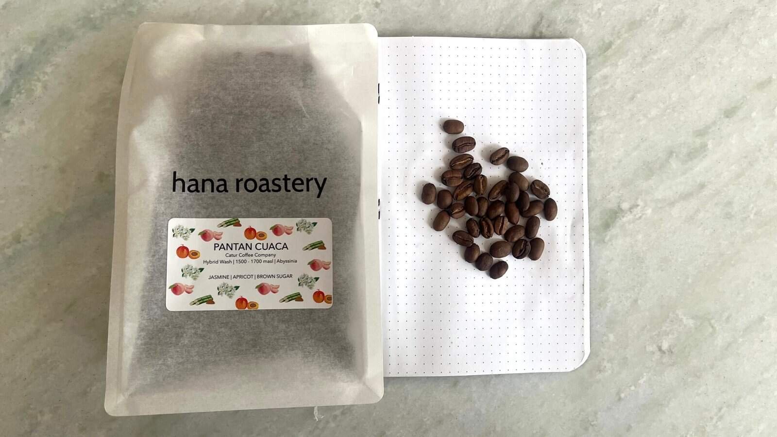 Smooth roasted Pantan CUACA coffee beans from Hana Roastery with info on flavor notes, packaged in a minimalist pouch, ideal for coffee enthusiasts and specialty coffee lovers.