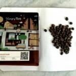 Rich coffee beans on dotted notebook page beside colorful coffee farm map, showcasing premium East Java Suket Mountain coffee, perfect for coffee enthusiasts and lovers of specialty coffee in the UK.