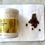 Roasted Sumatran coffee beans and a branded coffee tin on an open notebook, showcasing premium Indonesian coffee quality and specialty coffee beans for coffee lovers.