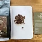 Rich roasted Ethiopian coffee beans and tasting notes in a modern coffee guide on a wooden table.