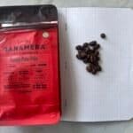 Rich coffee beans and Tanamera Indonesian coffee packaging on a dotted notebook, highlighting premium single-origin coffee, Indonesian brew, and coffee beans for brewing enthusiasts.