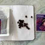 Rich, red wine grapes and preserved apricots from Yunnan, China, displayed with a notebook and a promotional card, highlighting premium organic produce and traditional Asian flavours.