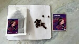 Rich, red wine grapes and preserved apricots from Yunnan, China, displayed with a notebook and a promotional card, highlighting premium organic produce and traditional Asian flavours.