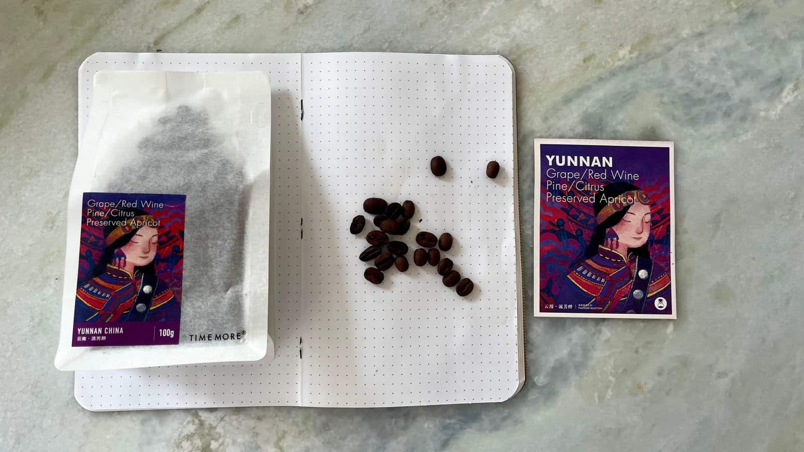 Rich, red wine grapes and preserved apricots from Yunnan, China, displayed with a notebook and a promotional card, highlighting premium organic produce and traditional Asian flavours.