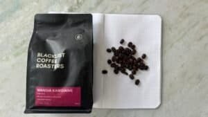 Blacklist Coffee Roasters Wanoja Kamojang premium Indonesian coffee beans on a dotted notebook with coffee beans.